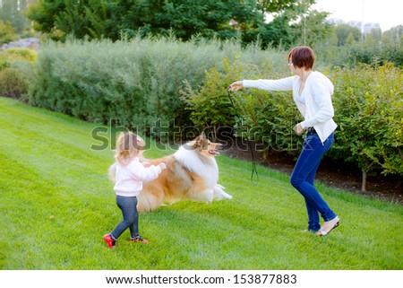 Mom and daughter are trained collie dog in the park