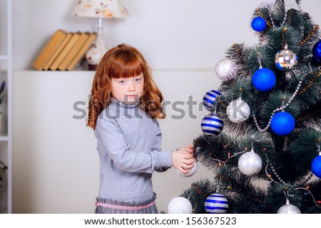 girl dresses up Christmas tree