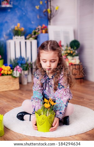 happy little girl. watering the flowers in the pot. Mother\'s Day, March 8, International Women\'s Day