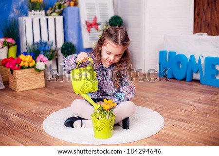 happy little girl. watering the flowers in the pot. Mother's Day,  International Women's Day