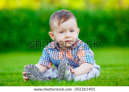 baby playing in the park. green lawn, smile, emotion, summer