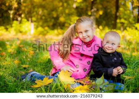 Happy children walk in autumn park
