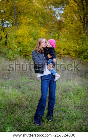 Beautiful mother and daughter on walk in autumn park