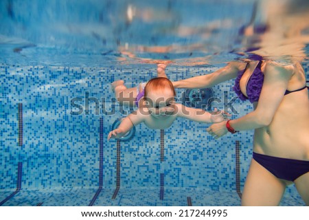 beautiful little boy swimming underwater. child development, disease prevention
