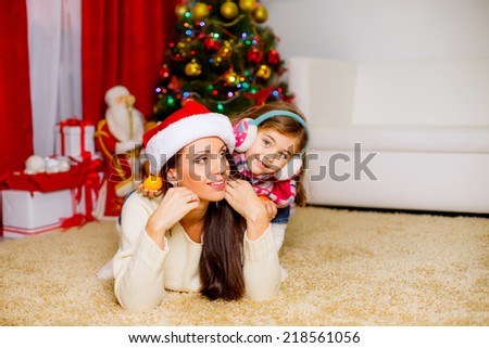 happy mother and daughter in a room near the Christmas tree