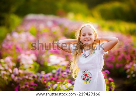 beautiful girl in the garden among the flowers. water the flowers. asters. autumn