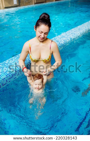beautiful mother with a child in the pool. swimming for infants, disease prevention