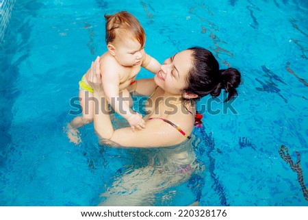 beautiful mother with a child in the pool. swimming for infants, disease prevention