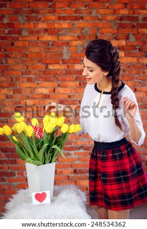 beautiful girl with a bouquet of yellow tulips. International Women\'s Day.