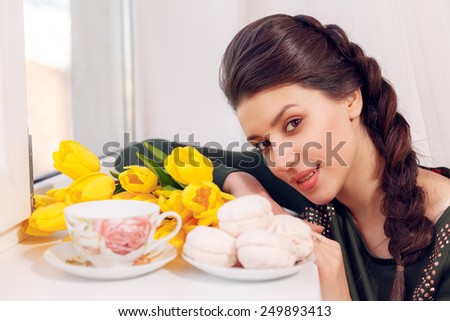 happy girl at the window with marshmallows and tulips. close-up, International Women\'s Day, Valentine\'s Day, March 8, Mother\'s Day