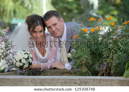 romantic bride and groom posing beside flower pots with flowers
