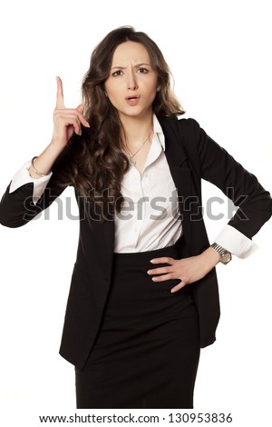 frowning and angry business woman pointing a finger upwards