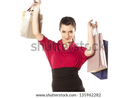 happy and smiling blue-eyed brunette holding shopping bags
