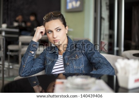 girl sitting alone in a cafe and waiting for someone