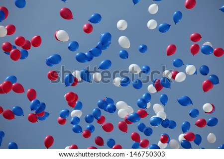 white, red and blue balloons flying all over the sky