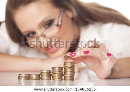 beautiful smiling girl with glasses line up coins in pillars