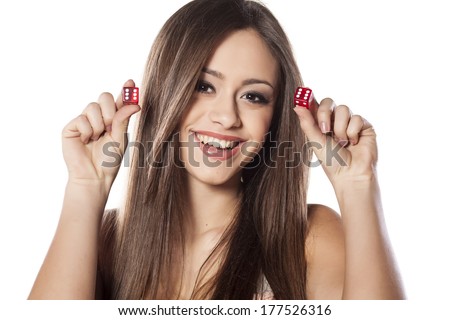 smiling girl holding a pair of dice for gambling with a winning combination