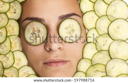 Portrait of beautiful woman with facial mask of cucumber slices on her face