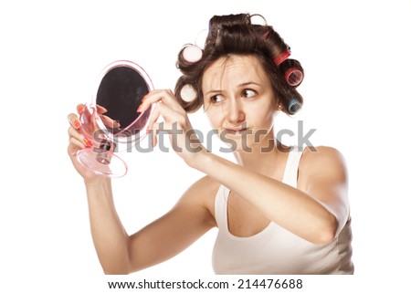 dissatisfied young woman without makeup and with hair curlers