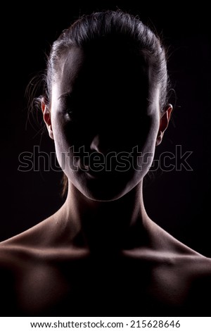 portrait of a woman with the face in shadow on a dark background