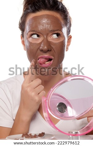 young woman testing a face mask with her tongue