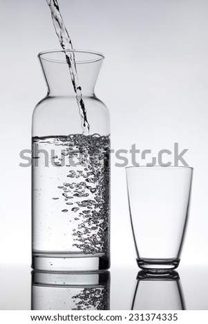 empty glass and a carafe filled with water