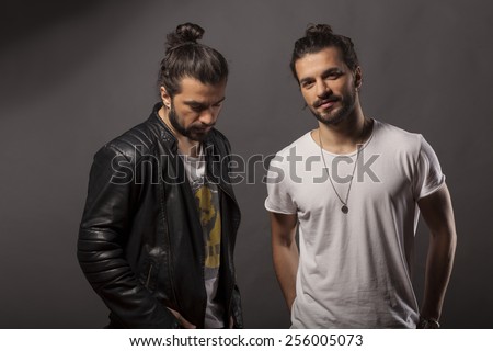 Two handsome young men with a beard and long hair in a bun