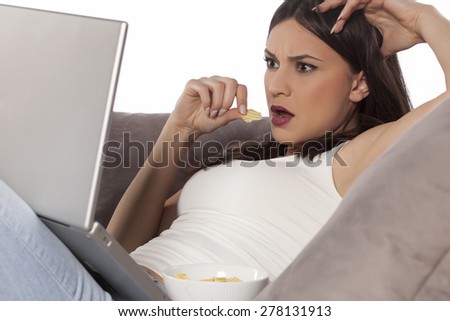 surprised young woman with a laptop on the couch