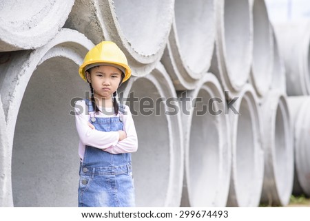 Kid civil engineer inspecting  huge concrete pipe with  moody pose