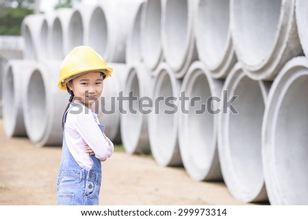 Kid civil engineer inspecting  huge concrete pipe in construction site