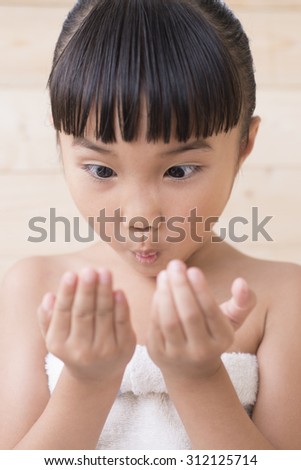Little girl take a bath and surprise with hand on wood wall background