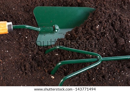 gardening tools shovel rake on peat background