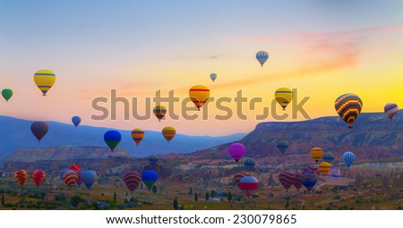 sunset Hot air balloons landing in a mountain Cappadocia Goreme National Park Turkey.