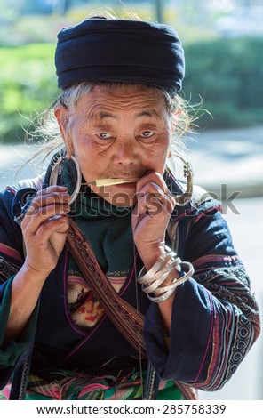 Sapa, Lao Cai Province, Vietnam - November 25, 2014: Hmong old woman at a dan moi wearing traditional attire in Sapa town on November 25, 2014, Lao Cai Province, North Vietnam.