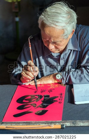 Hanoi, Vietnam - November 20, 2014 Calligrapher writing words on paper. Calligraphy is old culture of Vietnam