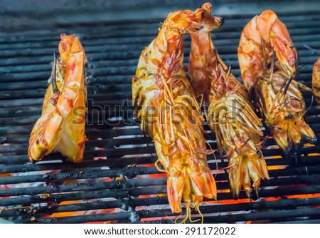 prepared shrimp, prawn grilled barbecued mixed seafood in BBQ Flames.