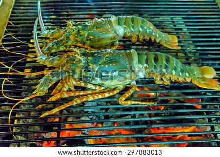 Lobster grilled barbecued seafood in BBQ Flames.