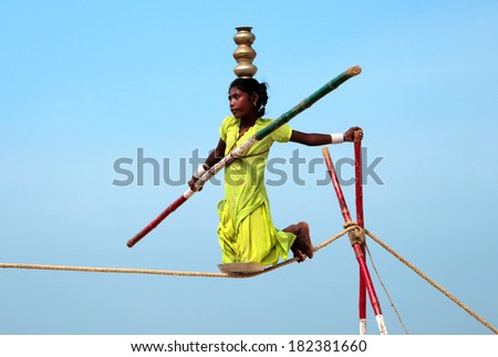 GOA, INDIA - FEB 12: Wandering indian tightrope walker playing on the beach of Goa, on Feb 12, 2008. Small groups of buskers traveling along the coast and arrange free shows for tourists on the beach