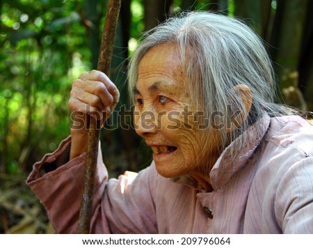 GUILIN, GUANGXI PROVINCE, CHINA - NOV 6, 2007:  Elderly chinese woman with a staff in her hand. In recent years, in China becomes more and more long-livers, whose age is more than 100 years