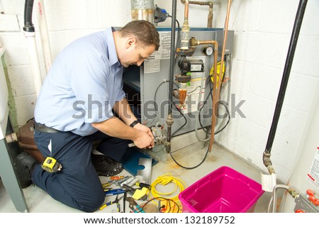 Plumber fixing gas furnace