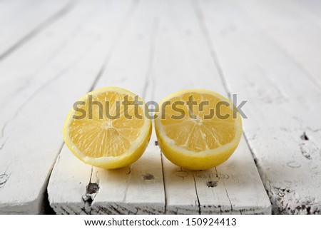 Lemon cut in half on a white aged table with copy space on top