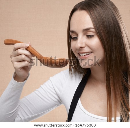 Female cook looking at wooden spoon