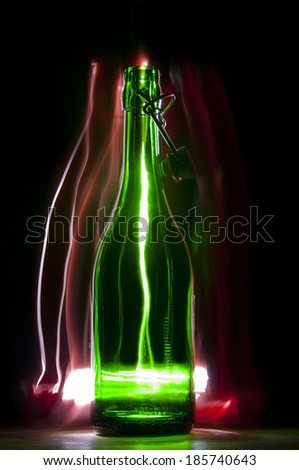 Green beer bottle with stopper. Frizlayt. Bottle on the red background of vertical lines of light. Lightning.