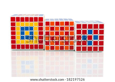 KRAGUJEVAC, SERBIA - MARCH 8, 2014: Three puzzle cubes on the white background. Rubik\'s Cube invented by a Hungarian architect Erno Rubik has many different variations.