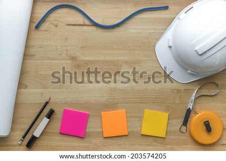 Architect\'s stuff. Architectural plans and measure, white hardhat on the office desk.