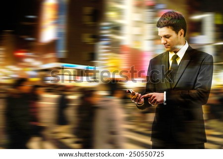Double exposure of businessman uses the smart phone on the city street, and motion blur background