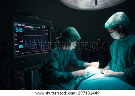Surgeons team working with Monitoring of patient in surgical operating room. selective focus on Monitor