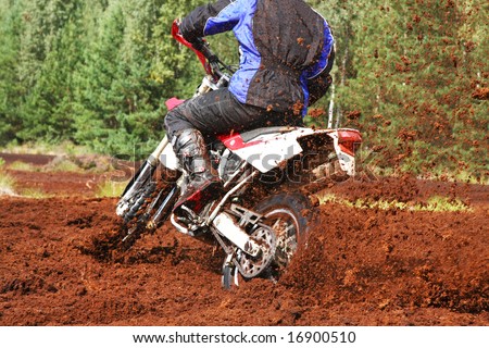 Off-road motorbike extreme cornering. Motion blur with flying dirt.