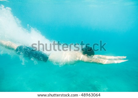 Man swimming under water, just jumped in.
