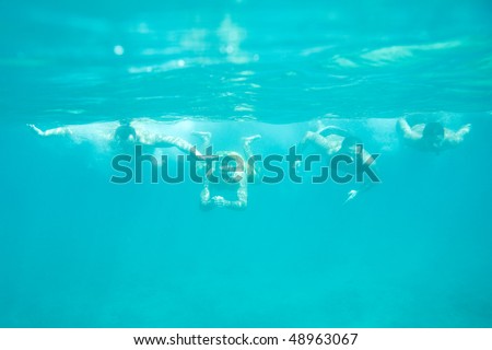 Four men swimming underwater in the sea